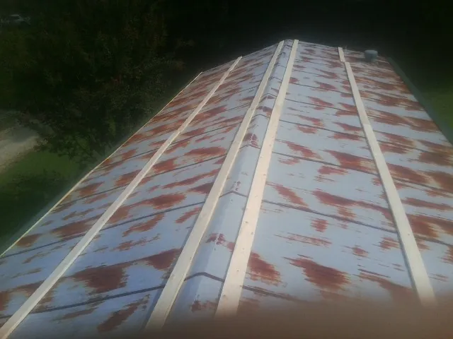 Rusted metal roof panels with new wood purlins before replacement — Storm Damage Roof Repair in Walthall by Roofing Brothers