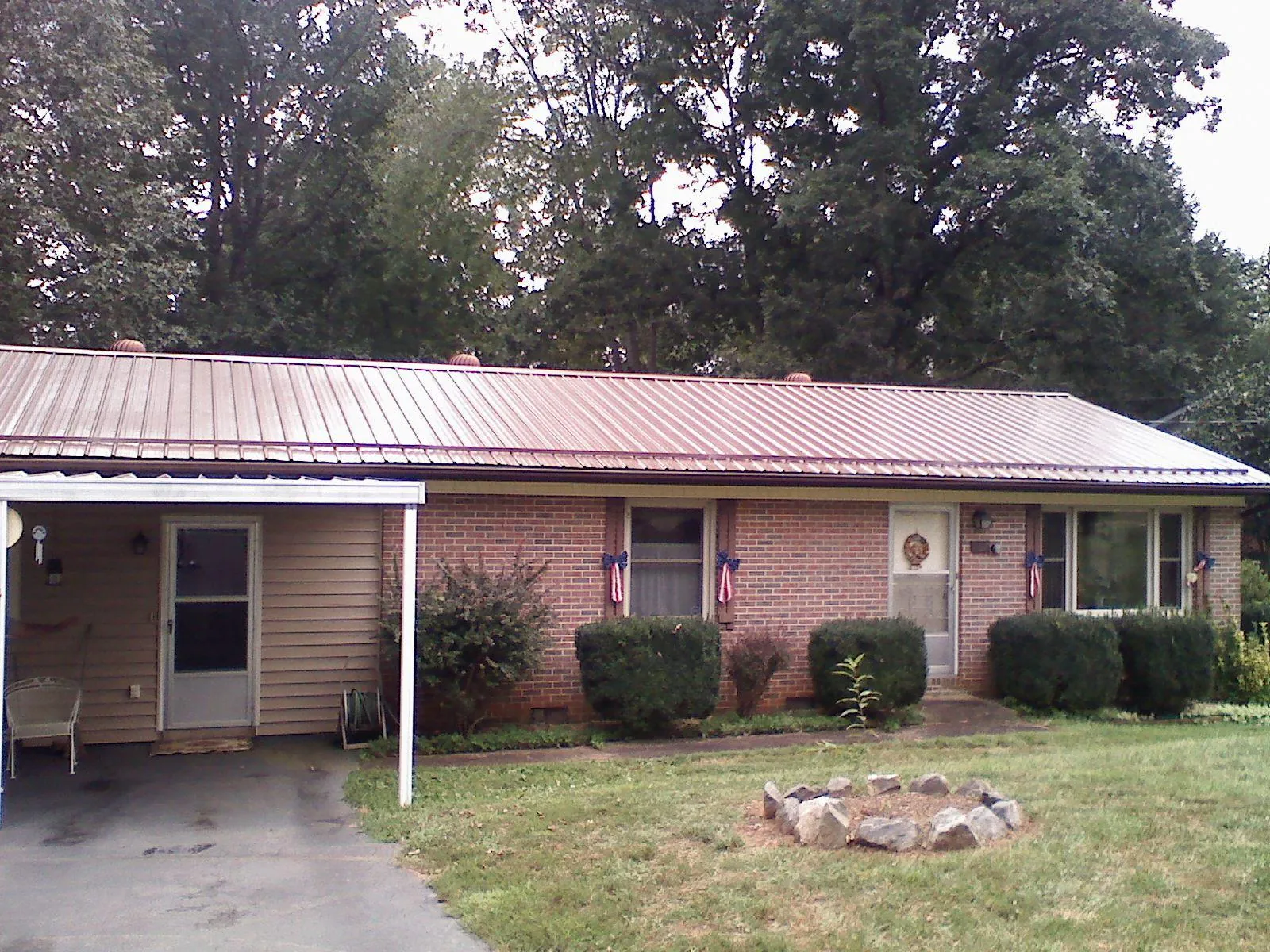 Bronze metal roof and carport on a brick ranch home — Roof Repair work by our crew in Walthall