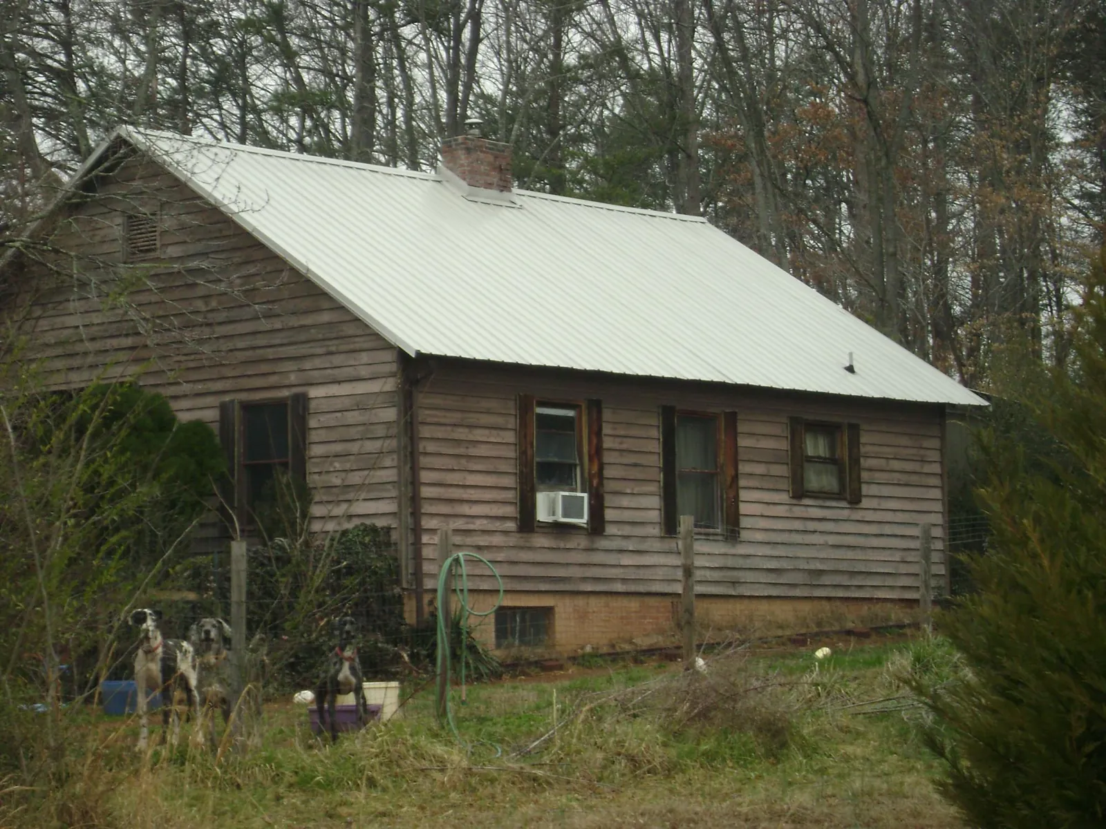 White metal roof on an old wood sided farmhouse, from a Metal Roof Installation job in Walthall